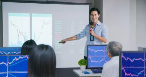 teacher in front of class of adults at computers
