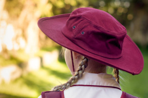 girl is school uniform and hat facing away