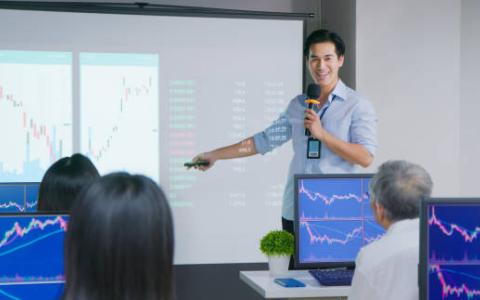 teacher in front of class of adults at computers