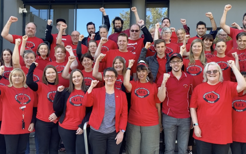 AEU president Meredith Peace and a group of members wearing red